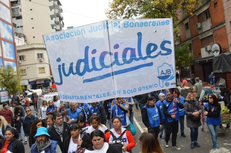 Trabajadores judiciales denuncian «deterioro de las condiciones laborales» y realizan una una jornada de protesta Compartir la nota Este miércoles 8 de abril trabajadores y trabajadoras judiciales de las 20 departamentales de la Asociación Judicial Bonaerense (AJB) realizarán una jornada de protesta para exigir a la Suprema Corte soluciones urgentes “ante el incumplimiento del máximo tribunal de compromisos de mejora de la carrera judicial y el deterioro de las condiciones laborales”.  Bajo las consignas de carrera judicial, seguridad y crisis de infraestructura, la jornada se desarrollará con diversas modalidades según cada departamental incluyendo asambleas, recorridas y actividades de difusión para visibilizar la problemática ante la sociedad.  Principales reclamos del sector:  – Carrera Judicial: Exigen la implementación de la subcategoría E para trabajadores con menos de 10 años de antigüedad y el pago de la permanencia en todos los cargos del escalafón.  – Jubilados/as: Demandan una solución definitiva para que jubilados/as y pensionados/as puedan percibir las subcategorías correspondientes al Acuerdo 4093.  – Mesas Técnicas: Solicitan la institucionalización de la mesa técnica de carrera judicial para reformas integrales y la creación de una mesa específica para abordar los graves problemas de infraestructura que afectan a las dependencias.  – Se reclama la cobertura de todos los cargos vacantes en las dependencias judiciales  – Seguridad: Reclaman respuestas ante los episodios de inseguridad en las sedes judiciales.  – Jornada Laboral: Solicitan el respeto de la jornada laboral establecida.  “La Suprema Corte está incumpliendo compromisos asumidos para mejorar la carrera judicial, en un contexto de fuerte deterioro salarial que afecta a todo el escalafón, especialmente a las categorías iniciales”, sostuvo el gremio en un comunicado de prensa.  Y agregó: “El máximo tribunal, al no participar de la paritaria ni resolver los temas que están a su alcance, demuestra una gravísima insensibilidad hacia quienes sostienen diariamente el funcionamiento de los tribunales”.  “Exigimos a la Suprema Corte soluciones concretas y urgentes que permitan mejorar las condiciones de trabajo en los 20 departamentos judiciales de la provincia”, finalizó la AJB, tras destacar que el objetivo de la medida es “obtener respuestas institucionales a una crisis que afecta el funcionamiento cotidiano de la justicia”.